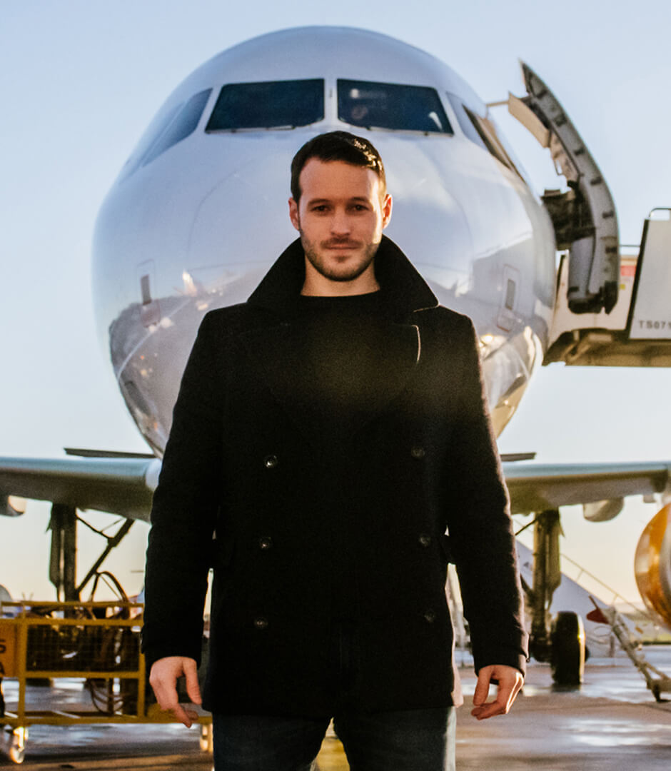 Corporate event entertainment Mind reader and hypnotist Aaron Calvert in front of Thomas Cook Airlines plane for hypnosis experiment with first time fliers